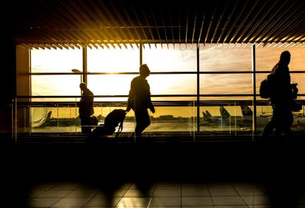 Travelers at an airport terminal during sunset